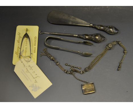 A silver envelope stamp box; Birmingham; a silver wish bone tongs;silver shoe horn; silver hafted button hook; etc