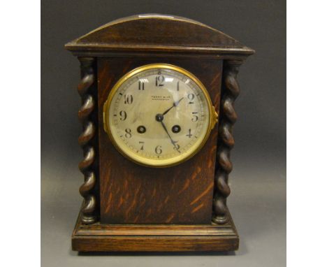 An early 20th century oak mantel clock, retailed by Terry & Co, Manchester, the architectural case flanked by barley twist pi