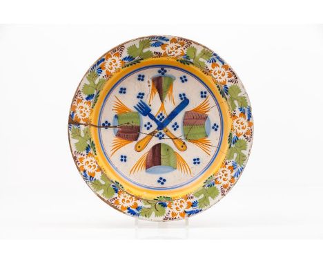 A platePortuguese faiencePolychrome "knife and fork with fish" decorationPortugal, 19th century(broken and glued)Diam.: 37 cm