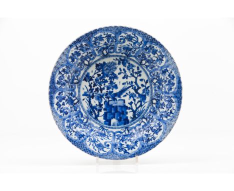 A large scalloped plateExport porcelainBlue and white decoration depicting landscape with birds, woods, rocks and flowersChin
