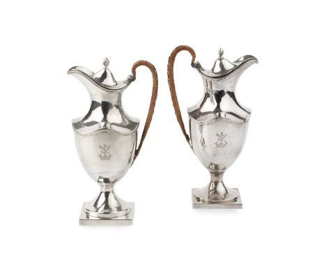 A pair of Edwardian silver baluster small ewers, with reeded edges, hinged covers and wicker covered handles, on square pedes