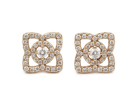 A pair of 'Enchanted Lotus' diamond ear studs by De Beers, each designed as an openwork quatrefoil-shaped cluster of graduate