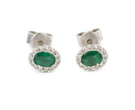 A pair of emerald and diamond cluster ear studs, each oval mixed-cut emerald bordered by round brilliant-cut diamonds, 18ct w