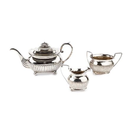 A George III silver teapot, of half-lobed design, the scroll handle with ivory insulators, on ball feet by Thomas Johnson, Lo