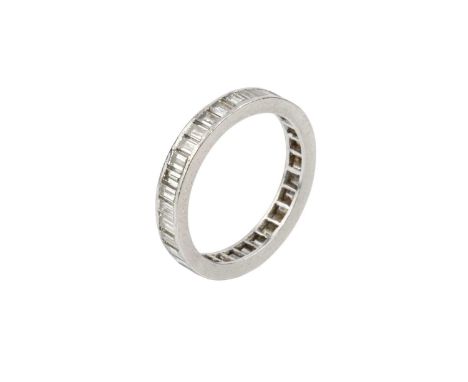A diamond full hoop eternity ring, channel set throughout with baguette-cut diamonds, white precious metal mounted, total dia