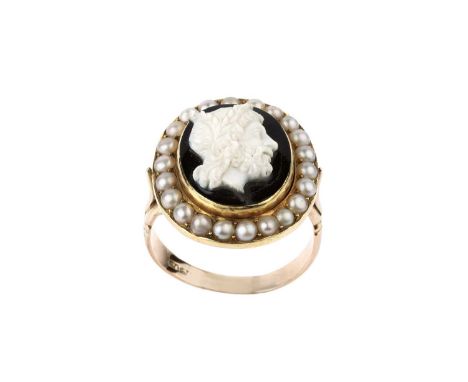 A cameo and half pearl cluster ring, the oval hardstone cameo carved to depict a classical male portrait profile, bordered by