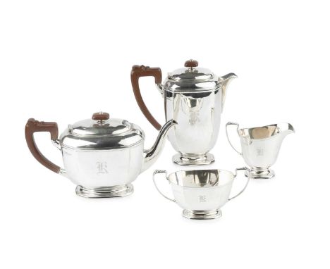 A George VI silver four piece tea service, of chamfered oval form, comprising teapot and hot water pot with composite handles