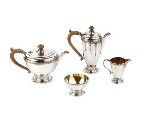 A silver four piece tea service, relief decorated with bands of celtic strapwork and motifs, on stepped circular bases with a