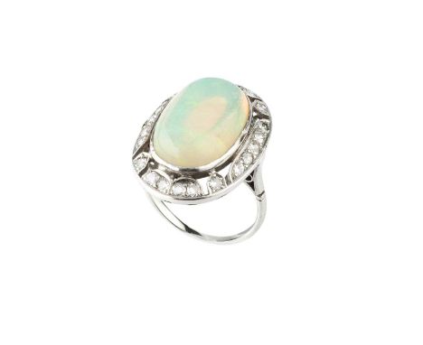 An opal and diamond cluster ring, the oval cabochon opal in collet setting, within an openwork border of round brilliant-cut 