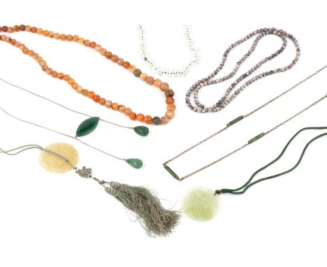A collection of jewellery, comprising two pierced and carved decorated circular pendants, an agate bead necklace, two further
