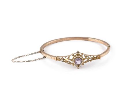 An amethyst and half pearl bangle, of hinged hollow oval form, the tapered frontispiece with a circular mixed-cut amethyst an
