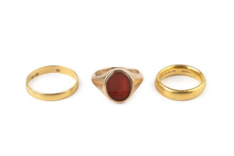 A 22ct gold wedding band, a further gold wedding band, (partial hallmark), and a carnelian signet ring, 9ct gold mounted, rin