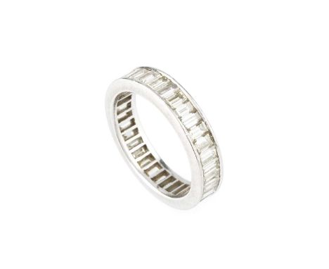 A diamond full hoop eternity ring, channel set throughout with baguette-cut diamonds, white precious metal mounted, total dia