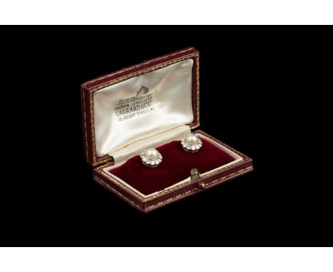 A pair of cultured pearl and diamond cluster ear studs, each half cultured pearl bordered by round brilliant-cut diamonds, on