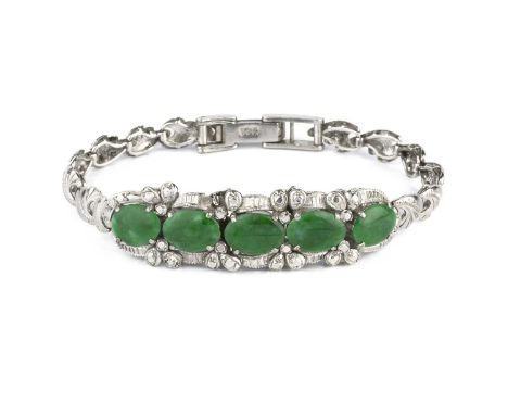 A jade bracelet, the convex articulated frontispiece with a line of five oval jadeite cabochons in claw settings, on a foliat