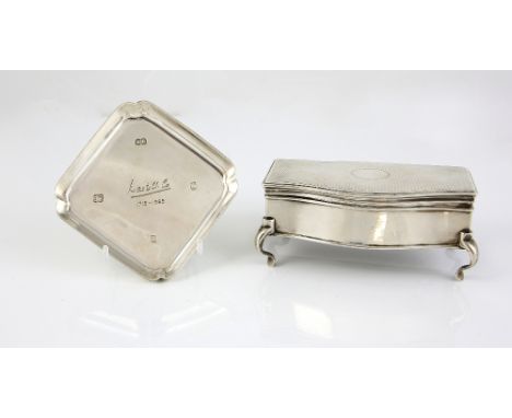 George V silver trinket box, on four scroll feet, the serpentine-front box with engine-turned decoration on the cover, and bl