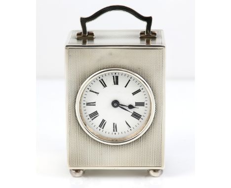 George V silver carriage clock with engine turned decoration, on bun feet, the white enamelled dial with Roman numerals and F