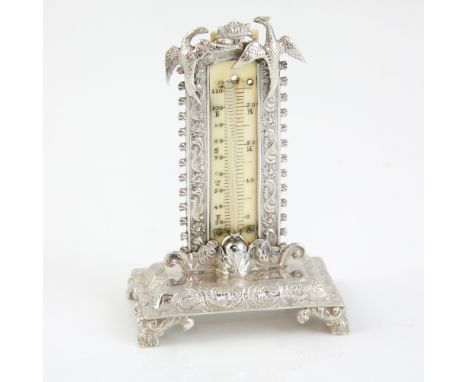 Victorian silver miniature thermometer on stand applied with Phoenixes, embossed scrolling decoration on four scroll feet, by