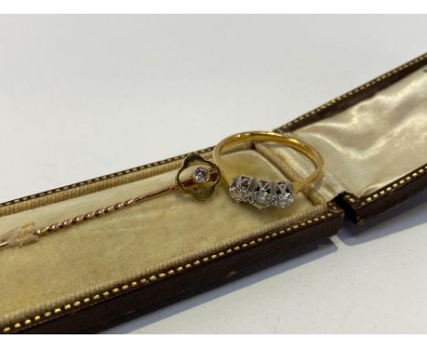 A 15ct gold diamond set tie pin and a 22ct gold diamond three stone ring