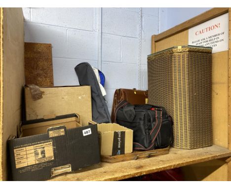 A shelf of Lloyd Loom style linen basket, horse brasses with cork board, sheet music and coins, camera equipment, brown leath