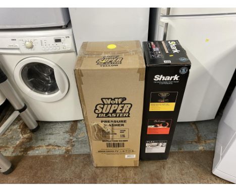 A boxed Shark corded stick vacuum cleaner and a Wolf Super Blaster pressure washer