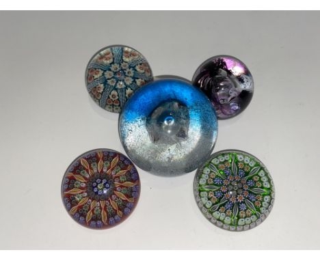 A Caithness glass paperweight in the 'Splashdown' pattern and four smaller glass paperweights