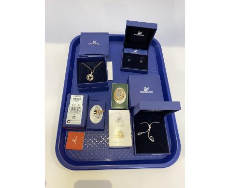 Five boxed Swarovski collectables to include; two necklaces, a pair of earrings, a basket of flowers and a birthday cake (5)