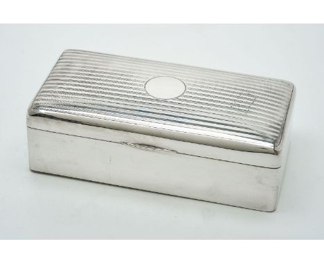 A silver rectangular cigarette box by Charles S Green &amp; Co Ltd, Birmingham 1920, the cover linear decorated, the sides pl