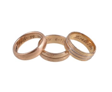 A gold coloured band ring, the shank inscribed Feb 14 1918, 7g; together with a further band ring stamped 750, 4.9g; and a ri