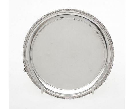 A silver circular waiter by R. Hodd &amp; Son, London 1971, with a raised beaded rim, on three ball-and-claw feet, 15cm (6in)