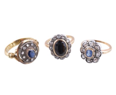 A sapphire and diamond cluster ring, the oval cut sapphire within a surround of lasque cut diamonds, finger size M; together 