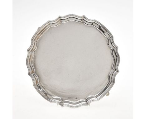 A silver shaped circular salver by A. E. Poston &amp; Co. Ltd, Sheffield 1946, with a raised moulded rim, on four scroll feet