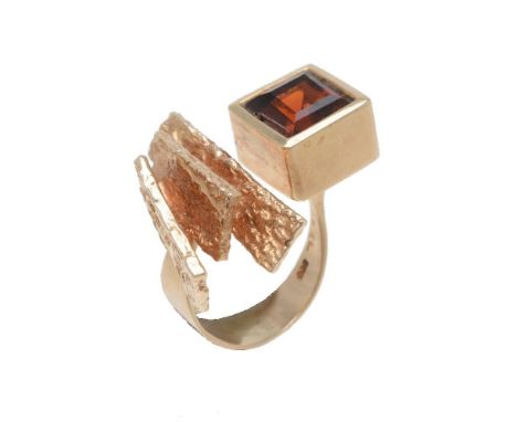 A 1970's Danish citrine abstract dress ring, the step cut citrine within a collet setting, to a tapered shank to a trio of te