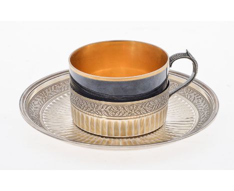 A French silver and porcelain cup and saucer by Henin &amp; Cie., Paris, 1838-1972 1st standard, circa 1900, with a ribbon ti