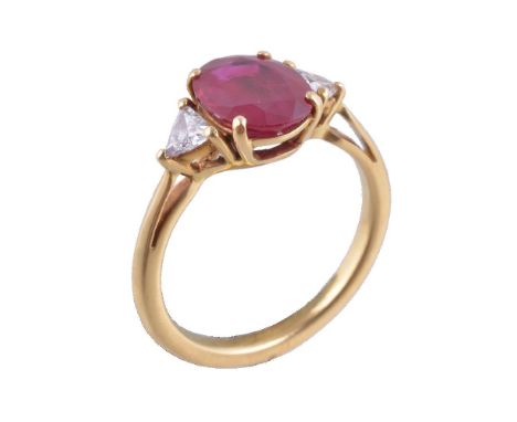 A ruby and diamond ring, the central oval cut ruby, estimated to weigh 2.06 carats, claw set between two triangular cut diamo