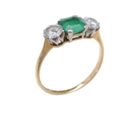 An emerald and diamond three stone ring, the central square cut emerald claw set between two brilliant cut diamonds, approxim