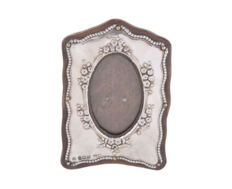 A silver small photograph frame by Boots Pure Drug Co., Birmingham 1911, shaped rectangular with an oval aperture and embosse
