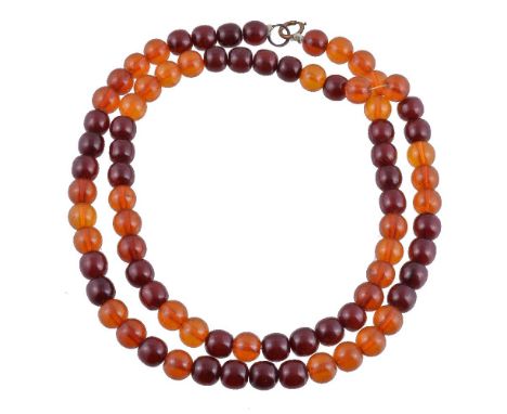 An amber coloured necklace, the cherry and amber coloured beads measuring 13mm to 14mm diameter, to a ring bolt clasp, 105cm 