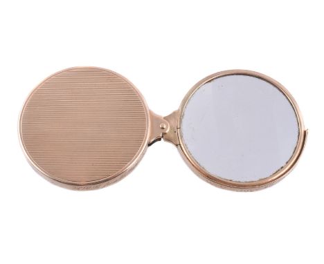 A 1930s gold magnifying eyeglass by Cartier, the swivel eyepiece within an engine turned case, hallmarked London 1931, signed