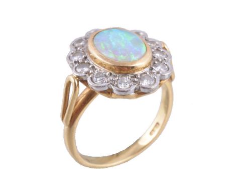 An 18 carat gold opal and diamond cluster ring, the oval shaped opal collet set within a surround of brilliant cut diamonds, 