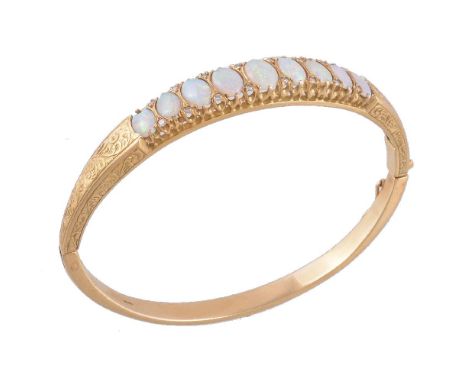 An 18 carat gold opal and diamond hinged bangle, set with graduating oval cabochon opals, with brilliant cut diamond accents,