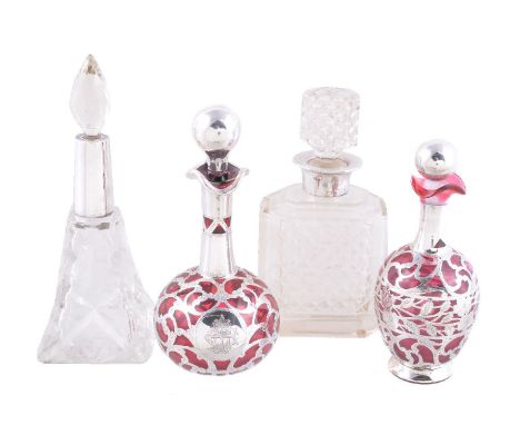 Four silver mounted glass scent or cologne bottles, comprising: a ruby encased example, maker's mark J.H. (incuse), 1900 or 1