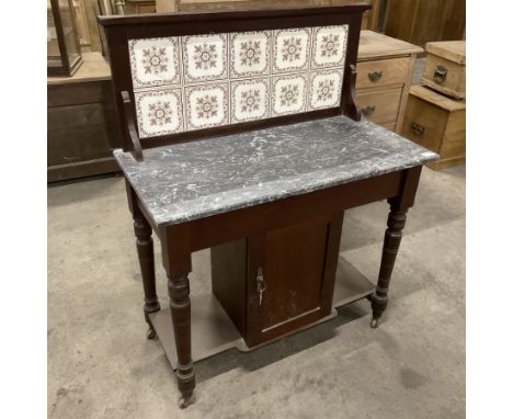 Early 20th century oak washstand, raised tile back over rectangular marble top, fitted with single cupboard, raised on ring t