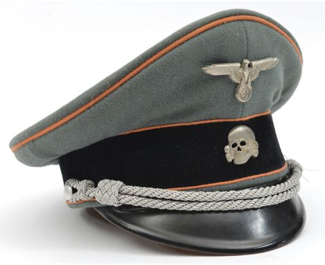 A Third Reich SS officer’s peaked cap, with faded orange piping for Feldgendarmerie and silver bullion cords, the lining with