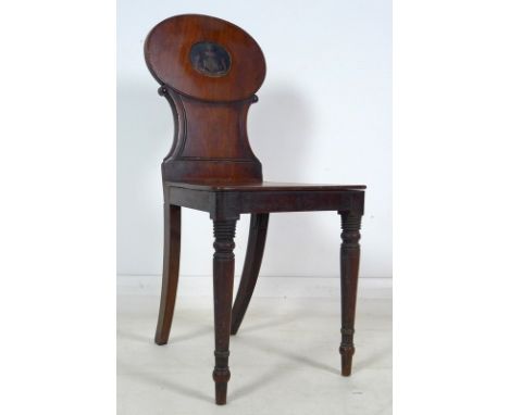 A 19th century mahogany armorial hall chair, the shaped back carved and painted with the crest of the Caffin family, shaped s