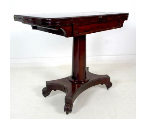 A William IV flame mahogany card table, swivel and fold over surface, raised on a plain gun barrel column and quatrefoil base