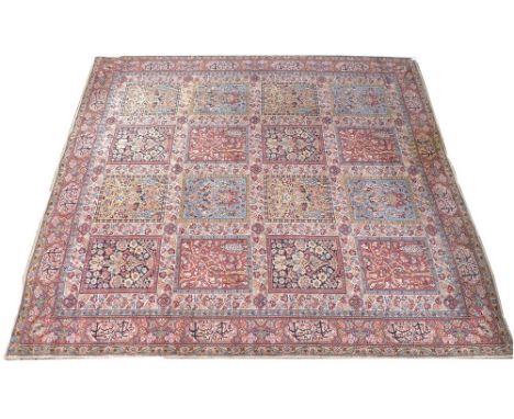 An early 20th century Persian wool carpet, beige / camel ground, with scrolling floral decoration and sixteen panel squares o