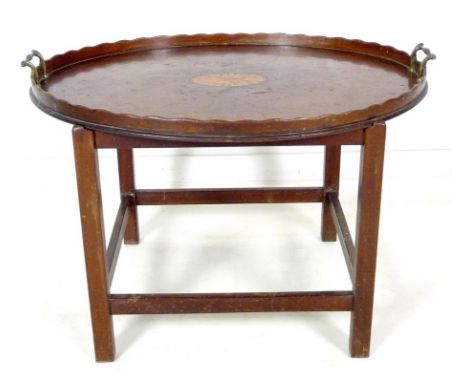 A late George III mahogany tray table, large oval tray with fan patera inlay, line border, a shaped edge gallery, and two bra