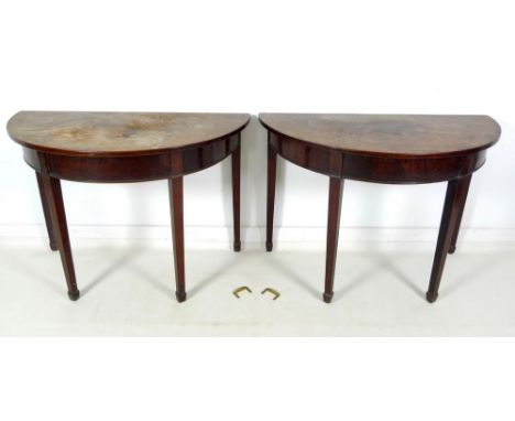 A pair of George III demi lune mahogany side tables, with plain friezes, raised on square section tapering supports, can be j