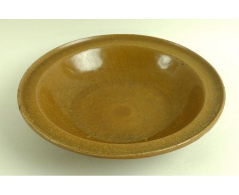 A rare Chinese shallow dish, Sung / Song Dynasty (960-1279), of porcellanous stoneware with upturned edge to rim and raised f